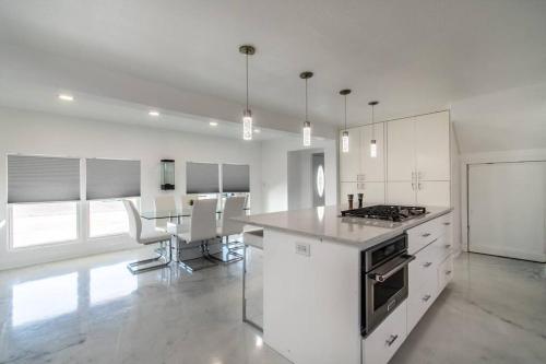 a kitchen with white cabinets and a table in it at Ocean Drive Splendor Awaits in Corpus Christi