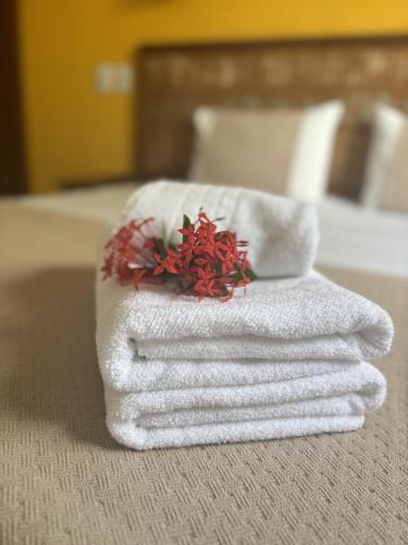 a pile of towels sitting on top of a bed at Pousada Alforria in Búzios