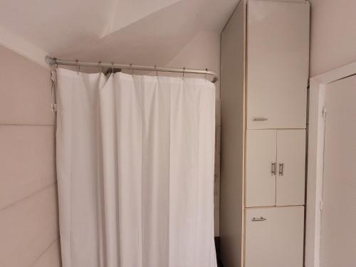 cortina de ducha blanca en un baño blanco en Benito blanco, en Montevideo