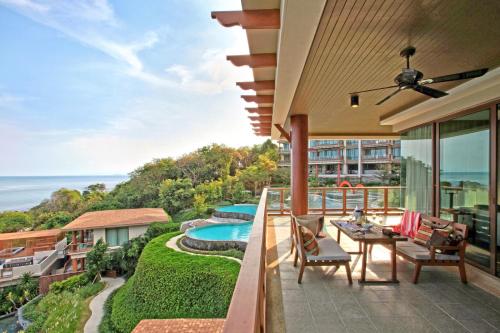 uma varanda com vista para uma piscina em ShaSa Resort - Luxury Beachfront Suites em Lamai