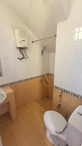 uma casa de banho com WC e um telefone na parede em Villas Dalia NA4/11 em Cianjur