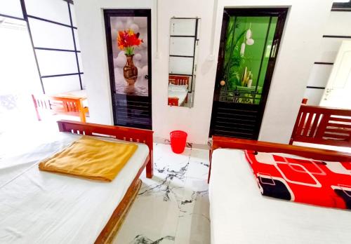 2 camas en una habitación con puerta en Mistey Valley Munnar en Anachal