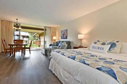 a bedroom with a large bed and a dining room at Eldorado J209 in Kahana
