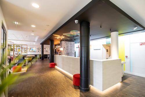 a lobby of a restaurant with a counter and chairs at Holiday Inn Express Hasselt by IHG in Hasselt