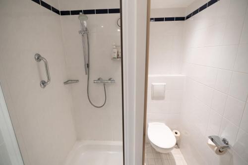 a white bathroom with a shower and a toilet at Holiday Inn Express Hasselt by IHG in Hasselt
