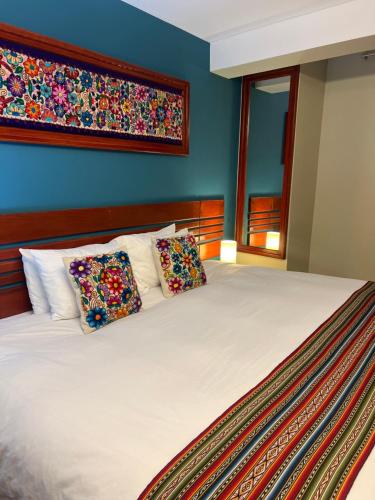 a bedroom with a large bed with two pillows at Hotel Chinchero Boutique & Tours in Chinchero