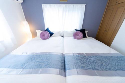 a bedroom with two beds and a window at Shiga Lakeside House in Hamabun in Imazu