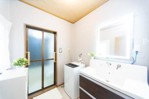 a bathroom with a sink and a toilet and a mirror at Shiga Lakeside House in Hamabun in Imazu