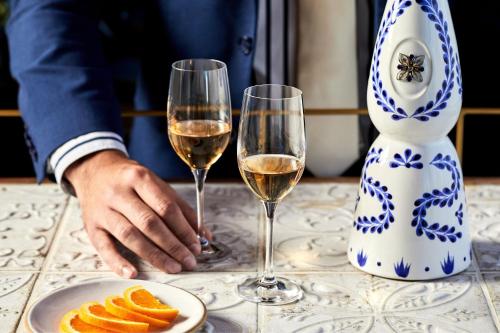 two glasses of white wine and a plate of orange slices at JW Marriott Los Angeles L.A. LIVE in Los Angeles