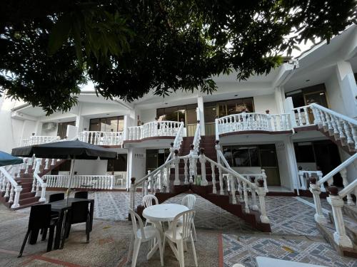 a building with white stairs and tables and chairs at Hotel Restaurante Versalles in Melgar