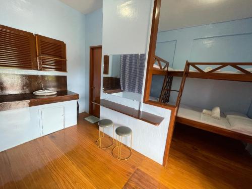 um quarto com 2 beliches e 2 bancos em Camiguin Blue Lagoon Cottages em Mahinog