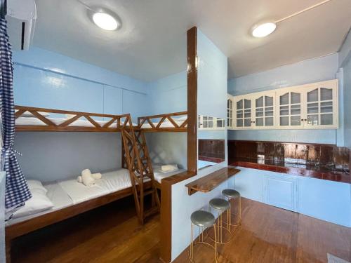 a room with two bunk beds and stools at Camiguin Blue Lagoon Cottages in Mahinog