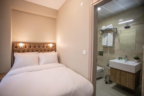 イスタンブールにあるBeyzas Boutique Hotels Suitesのベッドルーム1室(ベッド1台付)、バスルーム(シンク付)