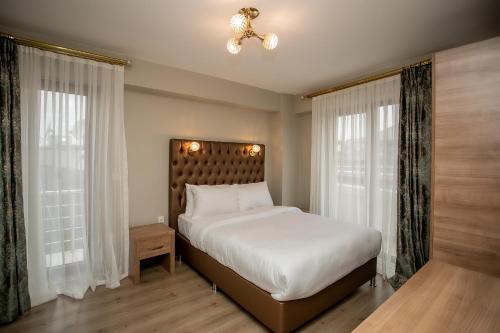 sypialnia z dużym białym łóżkiem i oknami w obiekcie Beyzas Boutique Hotels Suites w Stambule