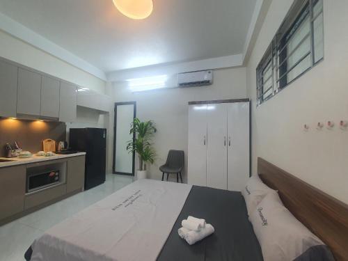 Apartment 59 Phạm Văn Đồng, Hà Nội في هانوي: غرفة نوم بسرير كبير ومطبخ