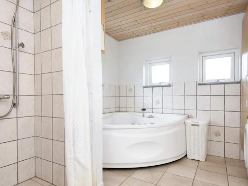 y baño blanco con bañera y ducha. en 8 person holiday home in B rkop, en Egeskov