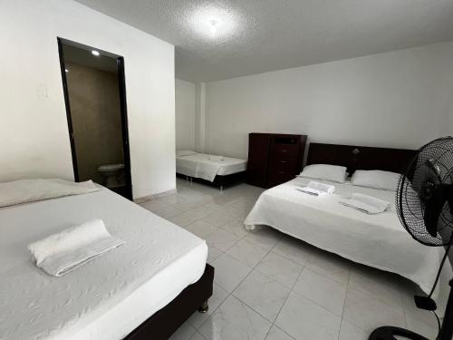 a hotel room with two beds and a fan at Hotel Restaurante Versalles in Melgar