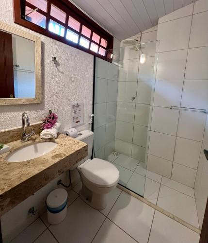 a bathroom with a shower and a toilet and a sink at Pousada Alforria in Búzios