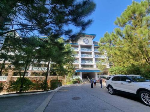 a white car parked in front of a building with a clock tower at PY Suites Tagaytay in Tagaytay