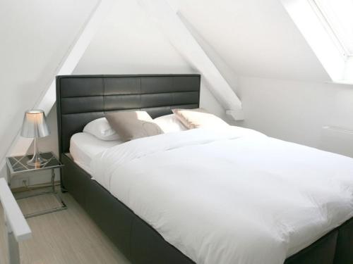 a bedroom with a large bed with white sheets and pillows at VISIONAPARTMENTS Cramerstrasse 2-6 - contactless check-in in Zürich