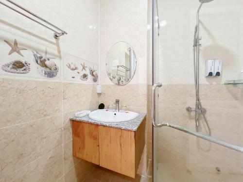een badkamer met een wastafel en een douche bij Sand Beach Resort in Mũi Né