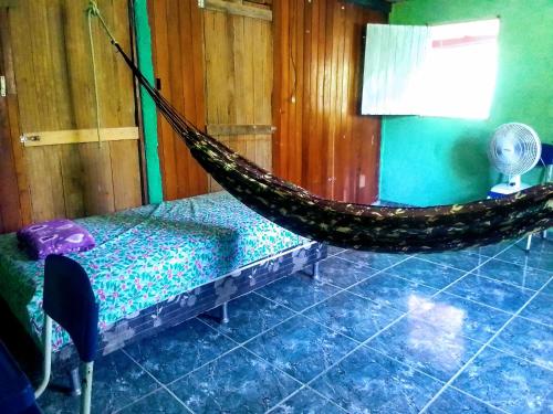 マナウスにあるQuarto compartilhado e camping na florestaのベッドとテーブル付きの客室内のハンモック