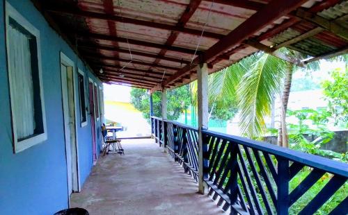 Un balcón de una casa con una mesa y una silla en Quarto compartilhado e camping na floresta, en Manaus