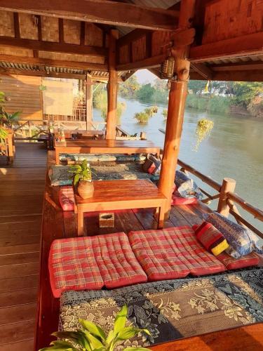 a bed on a boat with a view of a river at Crazy Gecko Dondet in Don Det
