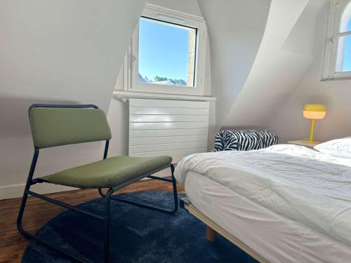 a bedroom with a bed and a chair next to a window at Maison 5 chambres à 150 m de la plage, rénovée, jardin, proche restaurants et commerces - FR-1-481-161 in Bénodet