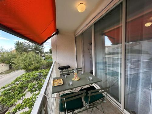 d'un balcon avec une table et une vue sur la rue. dans l'établissement Appartement T2 cabine climatisé avec garage et terrasse au Grau-du-Roi, 6 couchages, proche plage - FR-1-250-267, au Grau-du-Roi