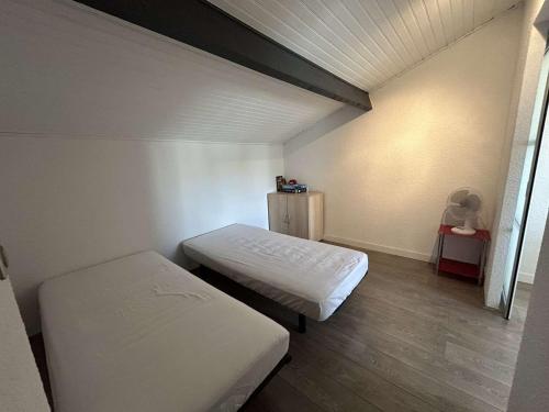 une chambre avec deux lits dans une pièce dans l'établissement Appartement T2 cabine climatisé avec garage et terrasse au Grau-du-Roi, 6 couchages, proche plage - FR-1-250-267, au Grau-du-Roi