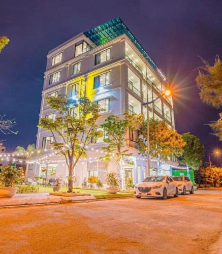 a white car parked in front of a building at Melanta Hotel - FLC Sầm Sơn in Sầm Sơn