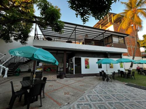 a building with tables and chairs and umbrellas at Hotel Restaurante Versalles in Melgar