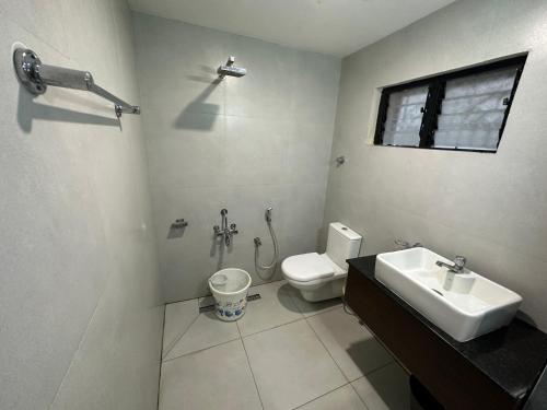 a bathroom with a sink and a toilet at Hotel Aiba Regency in Coimbatore