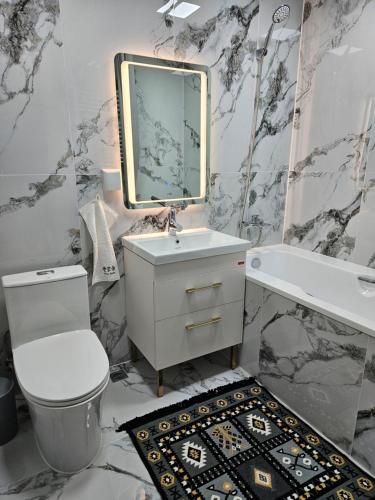 a bathroom with a toilet and a sink and a mirror at Fully furnished apartment fantastic view city center in Ulaanbaatar