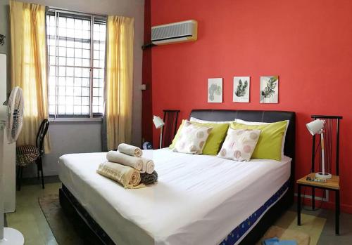 a bedroom with a large bed with a red wall at Cozy home@Friendship Garden 3 in Kota Kinabalu