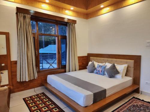 Un dormitorio con una cama grande y una ventana en The Morel House - A Forest Retreat, en Nārkanda