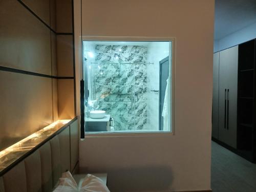 a bathroom with a window and a stone wall at G-Pinnacle Signature in Ilorin