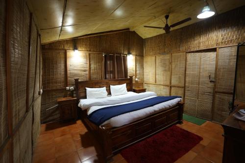 a bedroom with a bed in a room with wooden walls at Pinewood Nirvana Jungle Resort Shoghi in Shimla