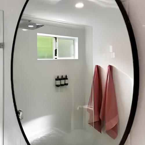 a mirror in a bathroom with red towels at Between the City and the Sea w/ King Size Bed in Perth