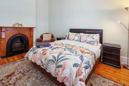 1 dormitorio con 1 cama y chimenea en Stanley Stay - Adelaide 3 Bdrm, Central Location, WiFi, en Woodville