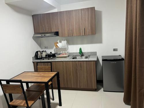 a kitchen with a sink and a table and a counter top at unit 23 greenhills, annapolis metro manila in Manila