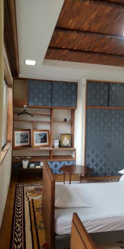 1 dormitorio con 1 cama y 1 mesa en 沼津ライダーハウスしんちゃん en Numazu