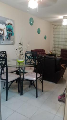 uma sala de jantar com uma mesa de vidro e cadeiras em Casa con alberca em Atlacholoaya