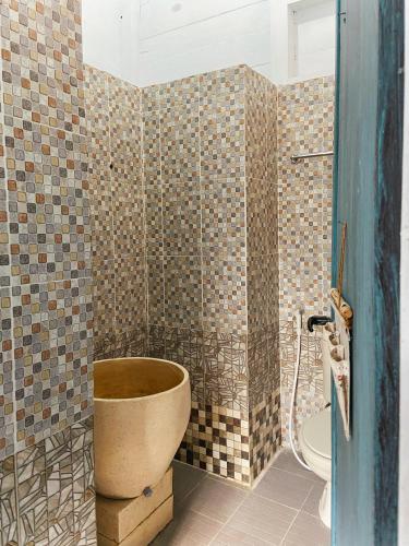 a bathroom with a toilet in the corner of a room at Ruma Kaca Simanindo Bed&Breakfast in Panjaitan