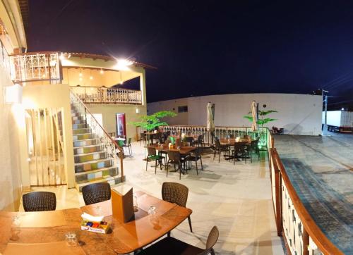 a restaurant with tables and chairs at night at Premium Hotel in Mombaça