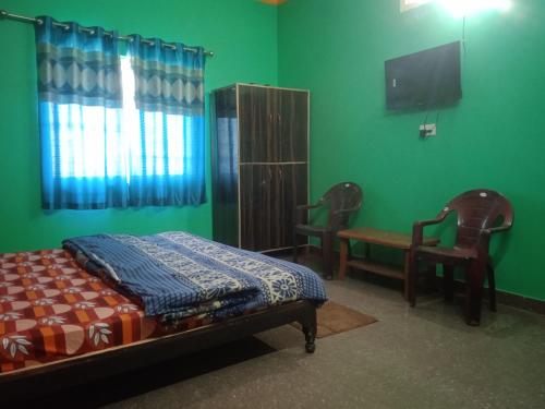 a bedroom with a bed and a tv and a chair at Bhagwati home stacy in Lansdowne