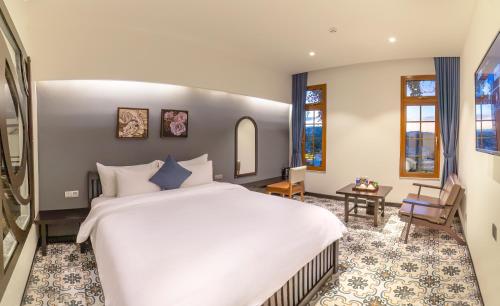 a bedroom with a large white bed in a room at Brick House Dalat Hotel in Da Lat
