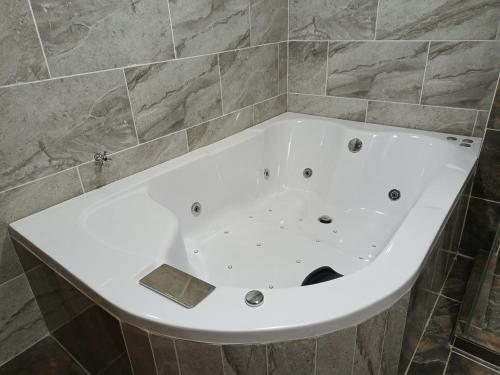 a white bath tub in a tiled bathroom at Agradable apartasol duplex in San Jerónimo
