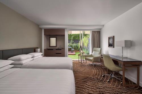 Habitación de hotel con 2 camas y escritorio en Melbourne Marriott Hotel, en Melbourne